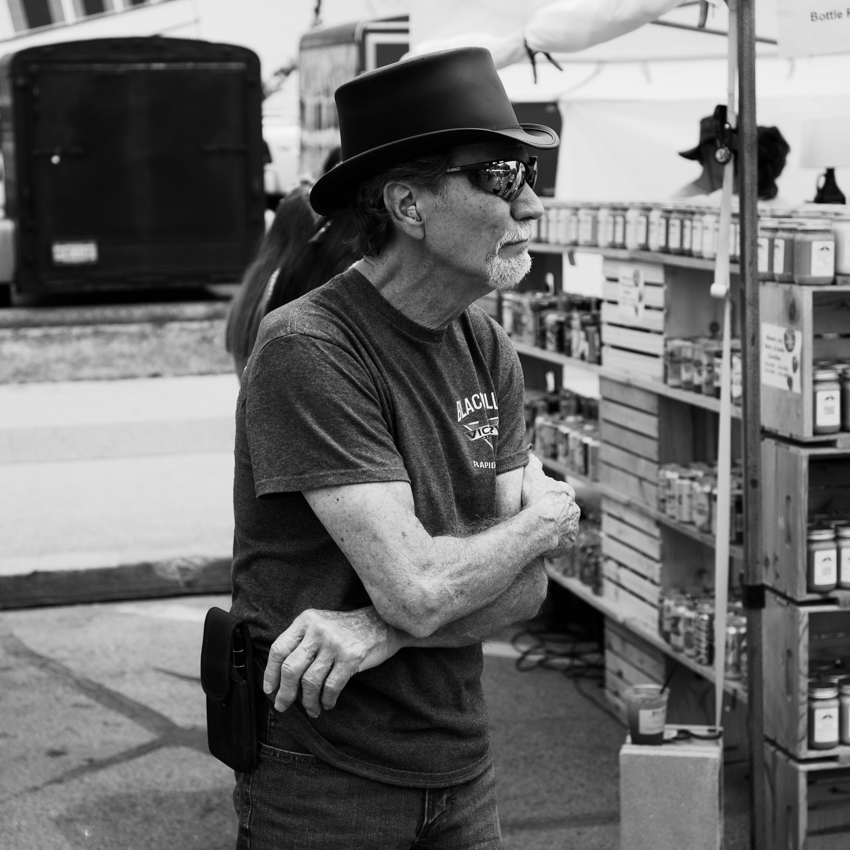 Older man in a top hat at a street fair